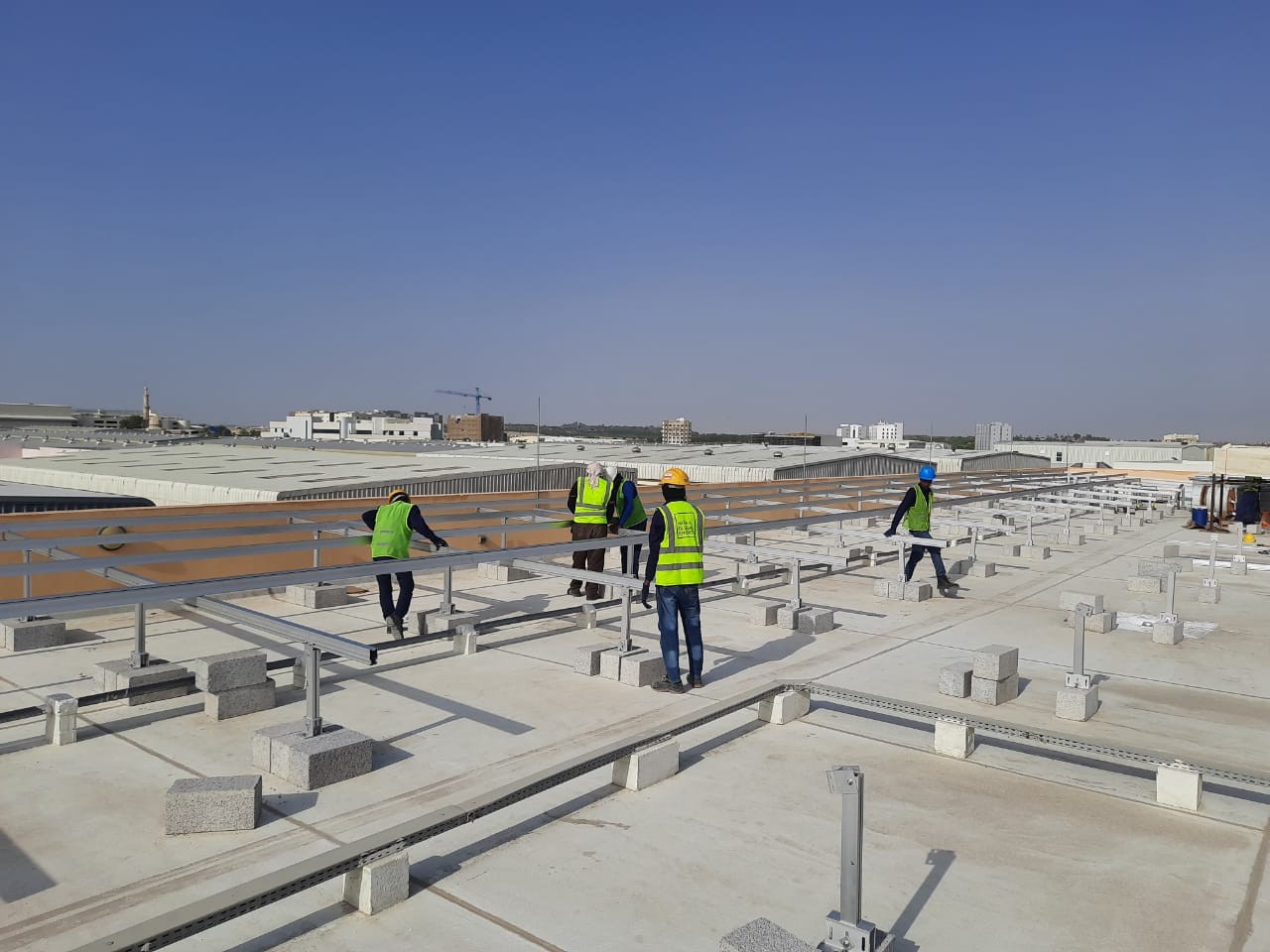 Workers installing Rooftop based Solar PV Structure on Flat roof tops